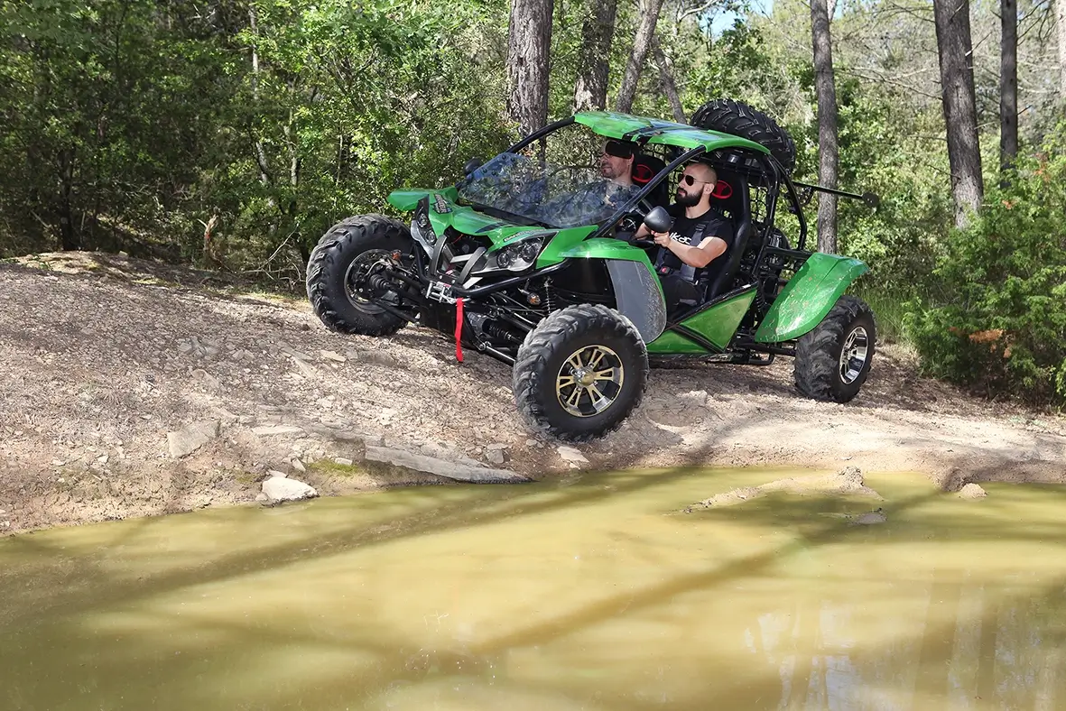 Buggy en zone de franchissement technique près d'un point d'eau